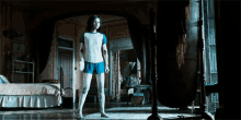 a woman in a white shirt and blue shorts stands in front of a mirror