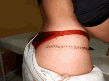 a woman has a tattoo on her hip that says do n't forget to love you