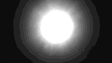 a bright white circle is shining in the dark .