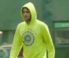 a man wearing a neon yellow hoodie with the word league on it