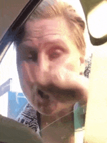 a man is driving a car and making a funny face with his mouth open