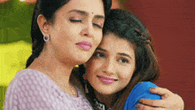a woman is hugging another woman who is crying .
