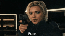 a woman is pointing a gun at the camera and saying " you " .