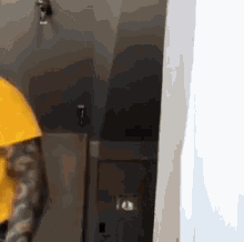 a person wearing a yellow hoodie is standing in a room