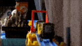 a toy train is going down a track in a room .