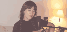 a woman is singing into a microphone while playing an acoustic guitar