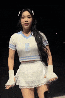 a woman wearing a white crop top and a white skirt with the letter s on it