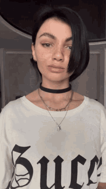 a woman wearing a black choker and a white t-shirt that says juice
