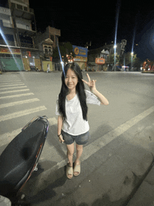 a young girl giving a peace sign in front of a t-mobile sign