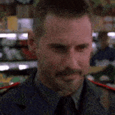 a man in a military uniform is standing in a grocery store .