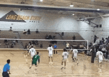 a volleyball game is being played in a gym with a long beach state sign on the wall