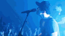 a man singing into a microphone with a crowd watching
