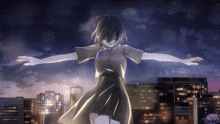 a girl with her arms outstretched in front of a city at night