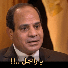 a man in a suit and tie has arabic writing on the bottom of his face
