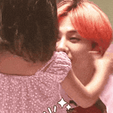 a man with red hair is kissing a little girl on the neck .