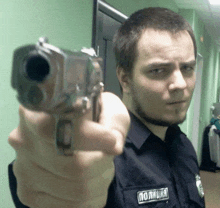 a man in a police uniform is pointing his gun at the camera