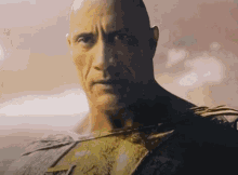 a close up of a bald man 's face with a blurred background .