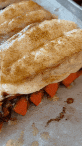 a close up of a sandwich with carrots on a tray