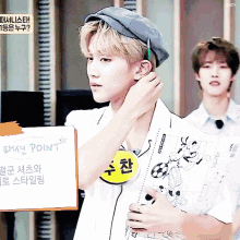 a man in a hat holds a piece of paper that says point