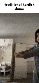 a man is doing a traditional kurdish dance in a room .