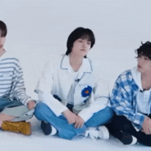 a group of young people are sitting on the floor .