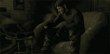 a man is sitting on a couch smoking a cigar