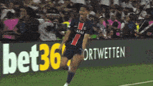 a soccer player wearing a qatar jersey celebrates on the field