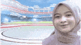 a woman wearing a purple hijab is smiling in front of a stadium