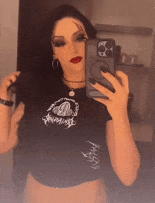 a woman is taking a selfie with her phone in a mirror .