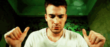 a man in a white shirt is making a funny face with his hands