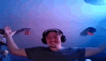 a man wearing headphones is dancing in a dark room .