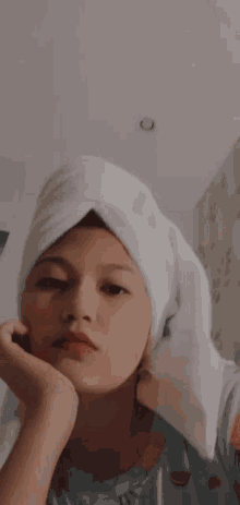 a close up of a person 's face with a towel wrapped around their head .