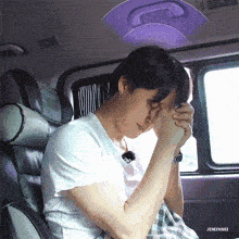 a man is sitting in the back seat of a car with his hands folded in prayer