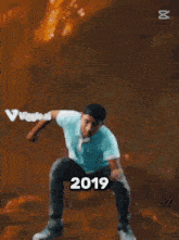 a man in a blue shirt is dancing with the year 2019