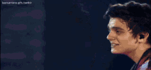 a man singing into a microphone with the words luansantana-gifs.tumblr written below him