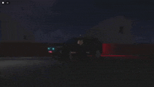 a car is parked in a dark parking lot at night with the lights on .