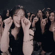 a girl with a bracelet that says ' g ' on it is surrounded by other girls