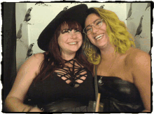 two women are posing for a picture and one is wearing a black hat