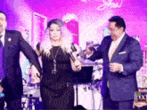 a woman in a black dress is dancing with two men in suits