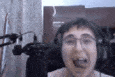 a man wearing glasses and headphones is making a funny face .