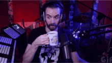 a man wearing headphones is drinking from a white mug