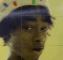 a close up of a person 's face wearing a hat and looking at the camera .