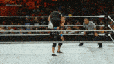a wrestler is being lifted in the air by another wrestler while a referee watches on