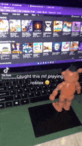 a toy foxy is standing in front of a laptop with the words " caught this mf playing roblox "