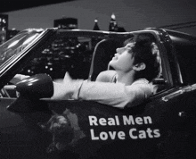 a black and white photo of a man in a car with the words real men love cats on the side
