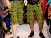 a pair of mannequins wearing green plaid shorts