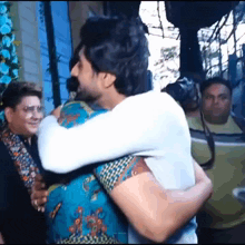 a man is hugging a woman in a crowd of people .