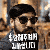 a man with a beard wearing sunglasses and a foreign language written on his face
