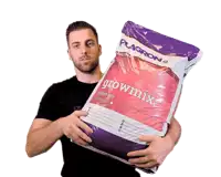 a man holding a large bag of growmix