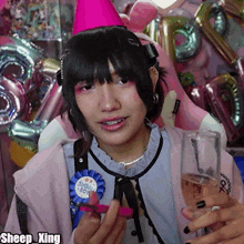 a woman wearing a pink party hat and holding a glass of champagne